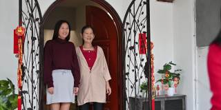 美丽的年轻亚洲妇女访问她的祖父母家给父母的礼物和食物在中国新年