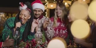 一群朋友在圣诞庆祝期间唱卡拉ok的滑动镜头