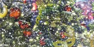 圣诞树在飘落的雪花下装饰着玩具和花环。