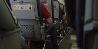 飞机内部，乘客坐在等待起飞的座位上