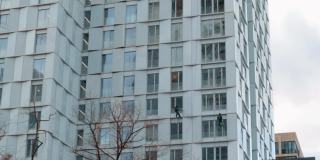 高层建筑商在一幢摩天大楼外立面上进行建筑维修