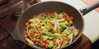 慢动作特写煎蔬菜在锅与蒸汽和没有盖