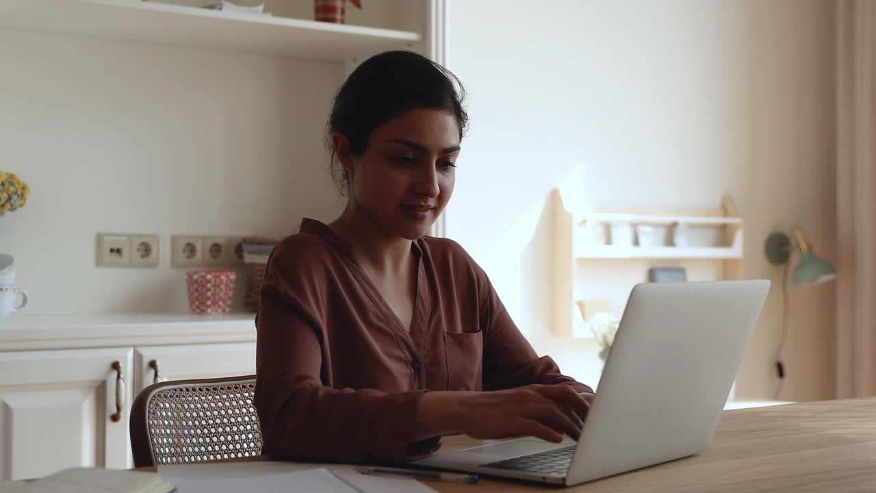 沉思的印度千禧一代女性在笔记本电脑上上网