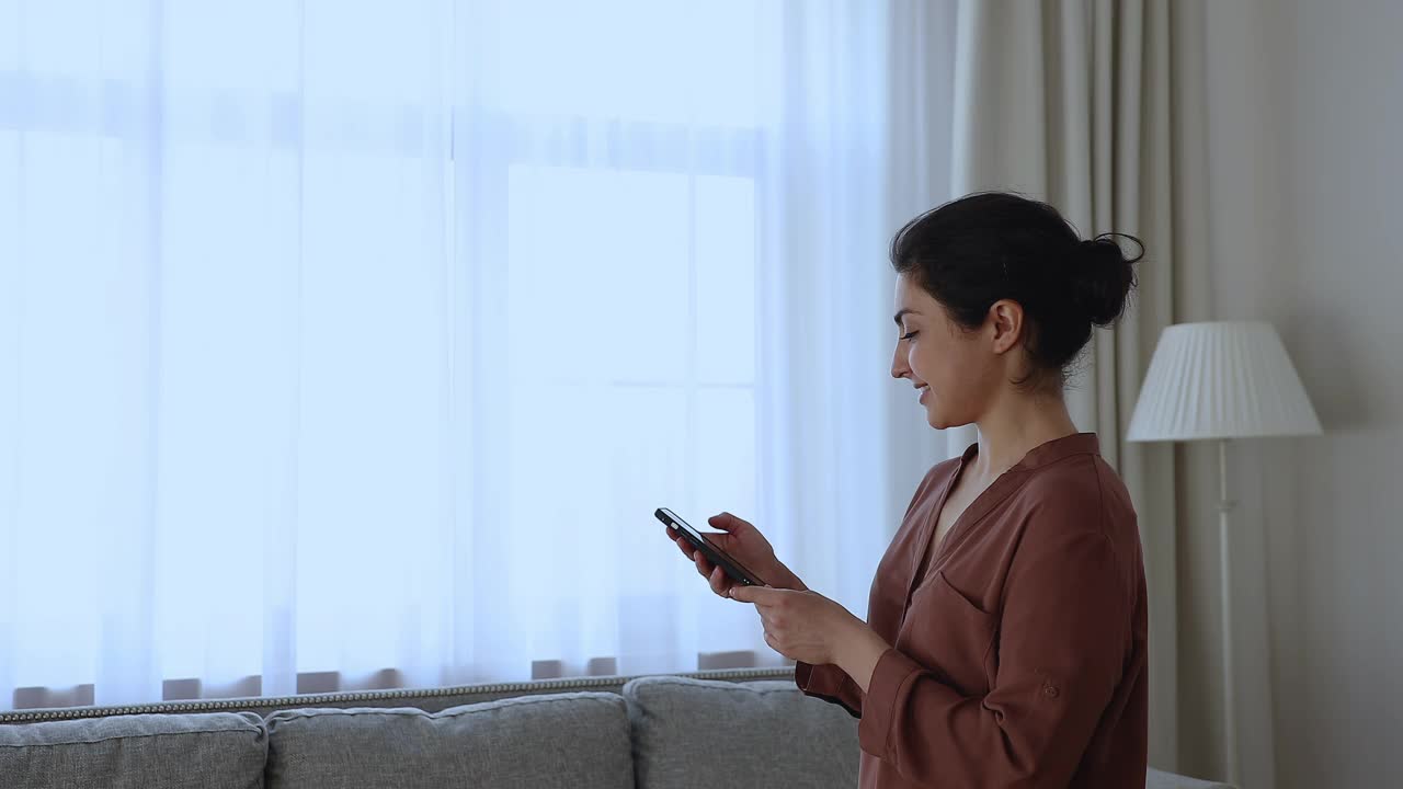 印度女性使用智能家居手机应用遮阳下窗
