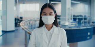 戴着口罩的韩国实验室女工作人员在室内做手势示意可以
