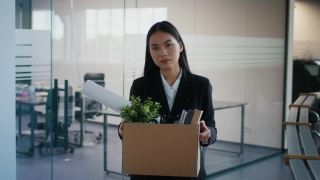 被解雇的亚洲妇女扛着箱子离开室内解雇后的工作场所视频素材模板下载