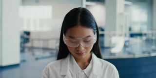 亚洲女性穿着实验服和眼镜在科学中心