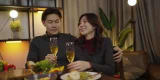 浪漫的亚洲夫妇边吃晚餐边碰杯