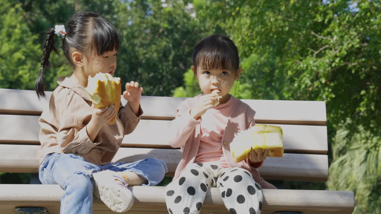 在公园野餐时，孩子们吃面包