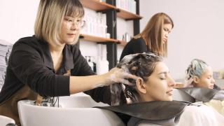 在发廊里，美发师正在为顾客洗头发、按摩头发。视频素材模板下载