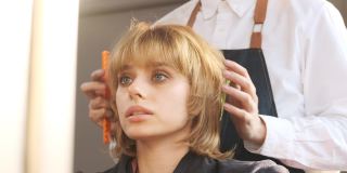 理发后，理发师整理发型和检查头发，慢动作拍摄。