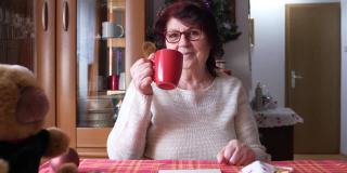 有趣的祖母在圣诞节喝咖啡