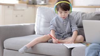 集中可爱的学前班男孩在耳机里画画在笔记本上听家教课视频素材模板下载