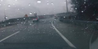在雨中开车，雨滴在挡风玻璃上移动