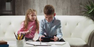 小男孩和妹妹在家看网上课程