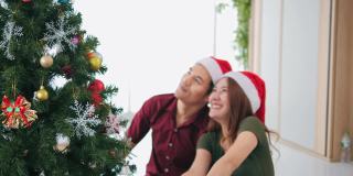亚洲夫妇在家中装饰圣诞树，营造节日气氛