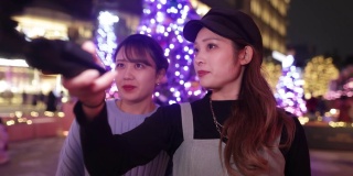 年轻的女性朋友在圣诞节的灯光下自拍视频