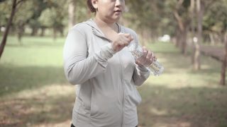 在公园里喝水的女人视频素材模板下载