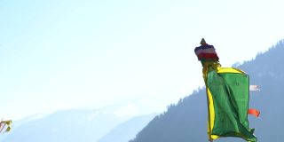 印度喜马偕尔邦马纳里附近Patlikuhal村的盘安宁马巴寺，彩色佛教藏经旗映衬着白雪覆盖的山脉