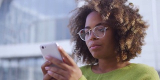 受到启发的黑人年轻女性在户外使用智能手机应用程序，技术