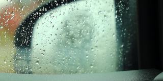雨落在后视镜和车窗上，在雨天开车