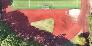 无人机鸟瞰图，学生在上海足球场奔跑