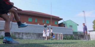 男孩足球运动员向球门踢球的慢动作