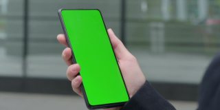 女商人使用智能手机与绿色Chroma屏幕