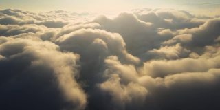 高空从飞机窗口俯瞰傍晚暴雨前形成的浓密蓬松的积云