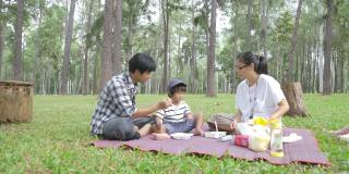 亚洲家庭在节日期间一起在松树公园野餐