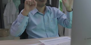 亚洲男子与虚拟现实眼镜耳机触摸空气在家里