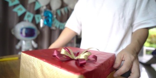 一名亚洲妇女在家为生日聚会装饰礼品盒