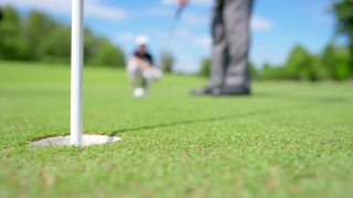 4K老年高尔夫球手在球道上将高尔夫球穿过洞视频素材模板下载