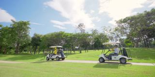 在夏日阳光明媚的高尔夫球场上驾驶高尔夫球车的亚洲老人的4K集团