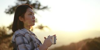 女人在户外放松与咖啡杯在山上的日落时间