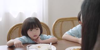 亚洲男孩和他的家人在一所房子里吃饭