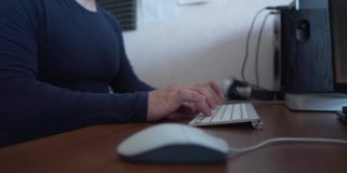 男性商人的手专业用户工作者使用键盘上打字坐在家庭办公桌旁与PC软件应用技术概念在线工作，近端视图