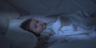 亚洲婴儿面对悲伤的情绪，晚上在床上哭泣。