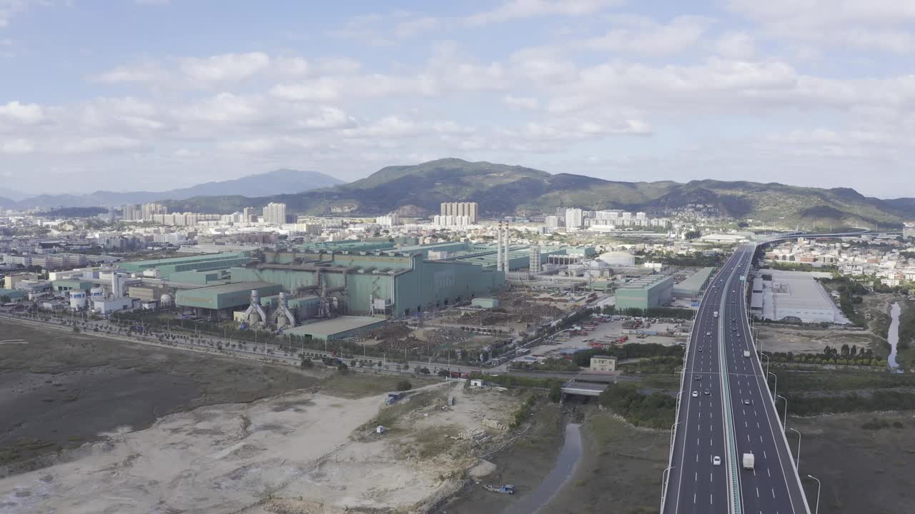 蓝天白云下高速公路和钢铁厂的航拍视频
