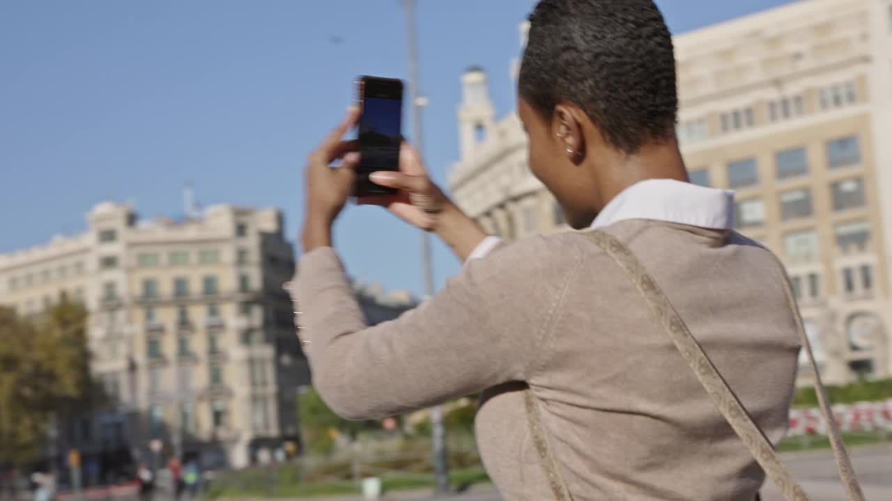 35岁左右的女性用智能手机拍摄Plaça de Catalunya