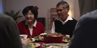 年夜饭的时候，老夫妇的爷爷和奶奶在给家人敬酒，庆祝春节