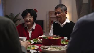 年夜饭的时候，老夫妇的爷爷和奶奶在给家人敬酒，庆祝春节视频素材模板下载