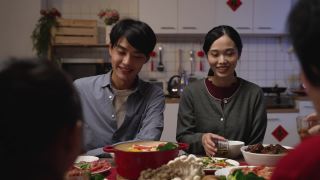 选择焦点的快乐年轻的亚洲夫妇喝茶敬酒他们的家人在中国农历新年团圆饭视频素材模板下载