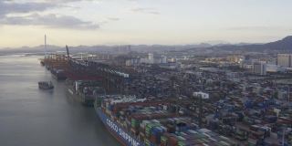 日落时分，几艘大型货轮停靠在一个商业码头的边缘