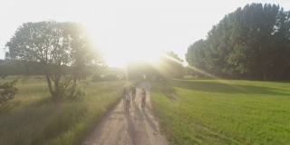 一个带着三个孩子在泥土路上骑车的家庭