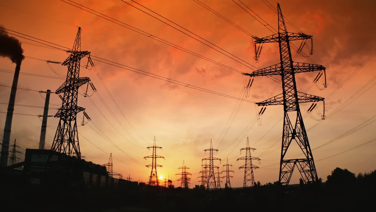 日落时分的配电站。在明亮的傍晚天空背景下，高钢铁塔和电线。Hi-voltage电线。上升了。