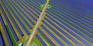 大型太阳能发电厂。成排的蓝色阳光电池在阳光下接收清洁的生态能量。太阳能可再生能源电站。鸟瞰图。
