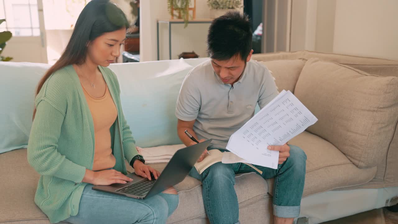 这是一对年轻夫妇在家里用笔记本电脑一起理财的4k视频