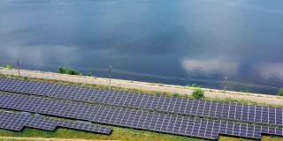 太阳能农场在美丽的蓝水背景。蓝色光伏太阳能电池板从太阳中产生清洁能源。鸟瞰图。