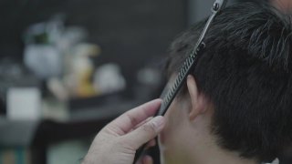 亚洲男孩坐在理发店剪发视频素材模板下载